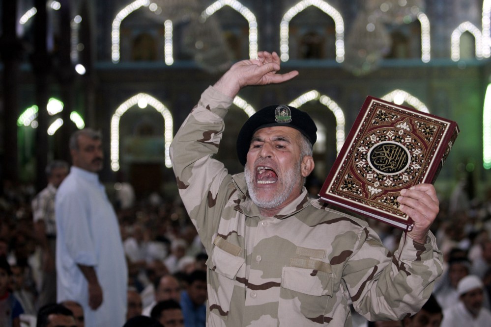 An Iraqi Shiite fighter chants slogans against the al-Qaida-inspired Islamic State group during Friday prayers in the Shiite holy city of Karbala, 50 miles (80 kilometers) south of Baghdad, Iraq, Friday.
