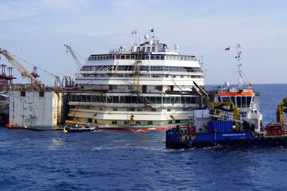 Workers carry on the operations on the luxury cruise ship Costa Concordia, to put put it afloat, on the tiny Tuscan island of Giglio, Italy on Monday. The shipwrecked Costa Concordia has been successfully put afloat in preparation to tow it away for scrapping.