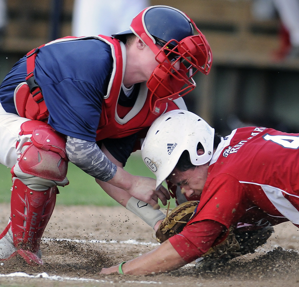 Post 51’s Trevor Gettig tags Red Barn’s Taylor Carrier at home during an American Legion playoff game in Augusta. Post 51 beat The Red Barn 4-0.