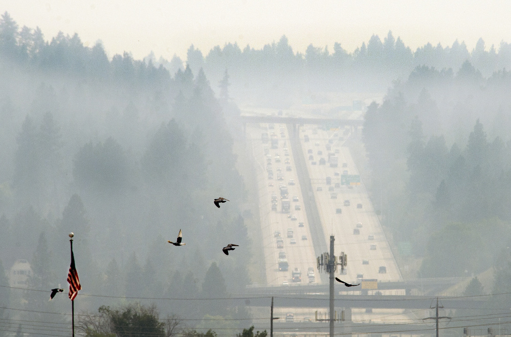 A blanket of gray smoke from the Carlton Complex of fires near Twisp, Wash., settles Thursday afternoon, July 17, 2014, on Sunset Hill in Spokane, Wash. (AP Photo/The Spokesman-Review, Dan Pelle)