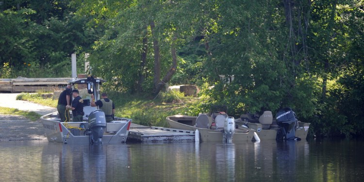 Search boats dock on the banks of the Kennebec River at the Madison boat launch on Friday. The body of Jordan Cummings was recovered at 8:55 a.m. Friday.