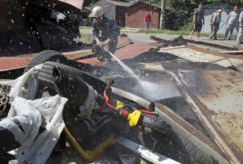 A firefighter extinguishes a destroyed garage after shelling in Donetsk, eastern Ukraine, Tuesday.  Local residents said the shelling came from the direction of the Ukrainian army’s positions.
