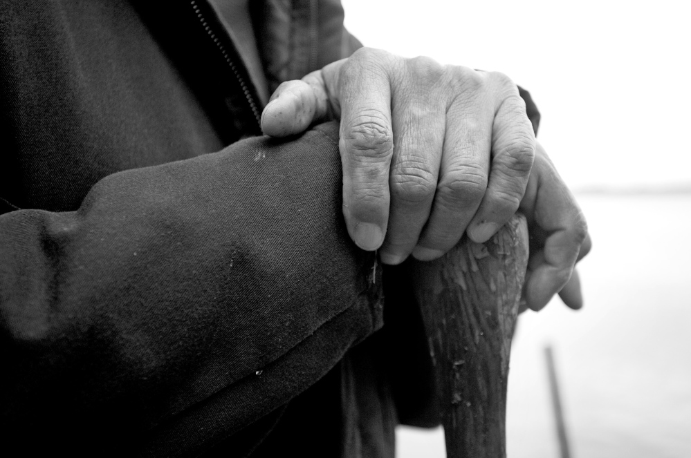 A Passamaquoddy elder rests his hands on an oar while working near Long Lake in Indian Township this spring. The people on the tribe’s two eastern Maine reservations have spent decades fighting for their rights while struggling to preserve their collective identity.