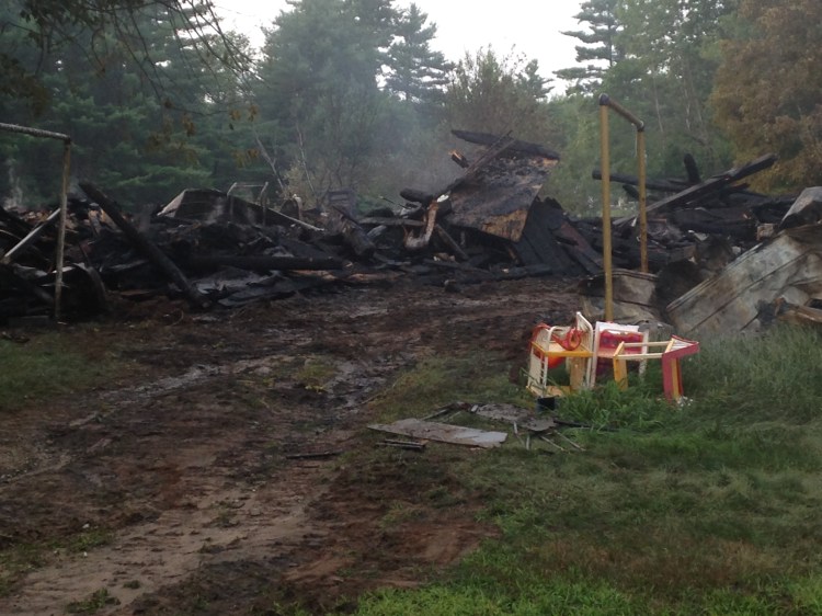 Plastic toy furniture sits melted near wreckage from a fire that destroyed a large barn in Leeds Friday. Fire Chief Glenn Holt said nobody was home when the fire broke out, but two people were taken to the hospital to be treated for smoke inhalation.