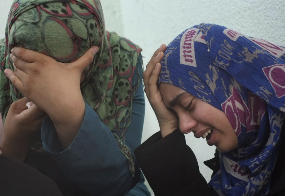 Palestinian relatives of the Abu Wahdan family cry outside the morgue of the Kamal Adwan hospital in Beit Lahiya after the bodies of three members of the family, that were killed in an overnight Israeli strike, were taken away for their funeral on Sunday. Jamila, 55, Hatem, 57, and Sanwara Abu Wahdan , 27, were killed at the hit, after the extended family of more than 40 people had sought refuge in Jebaliya from shelling elsewhere.