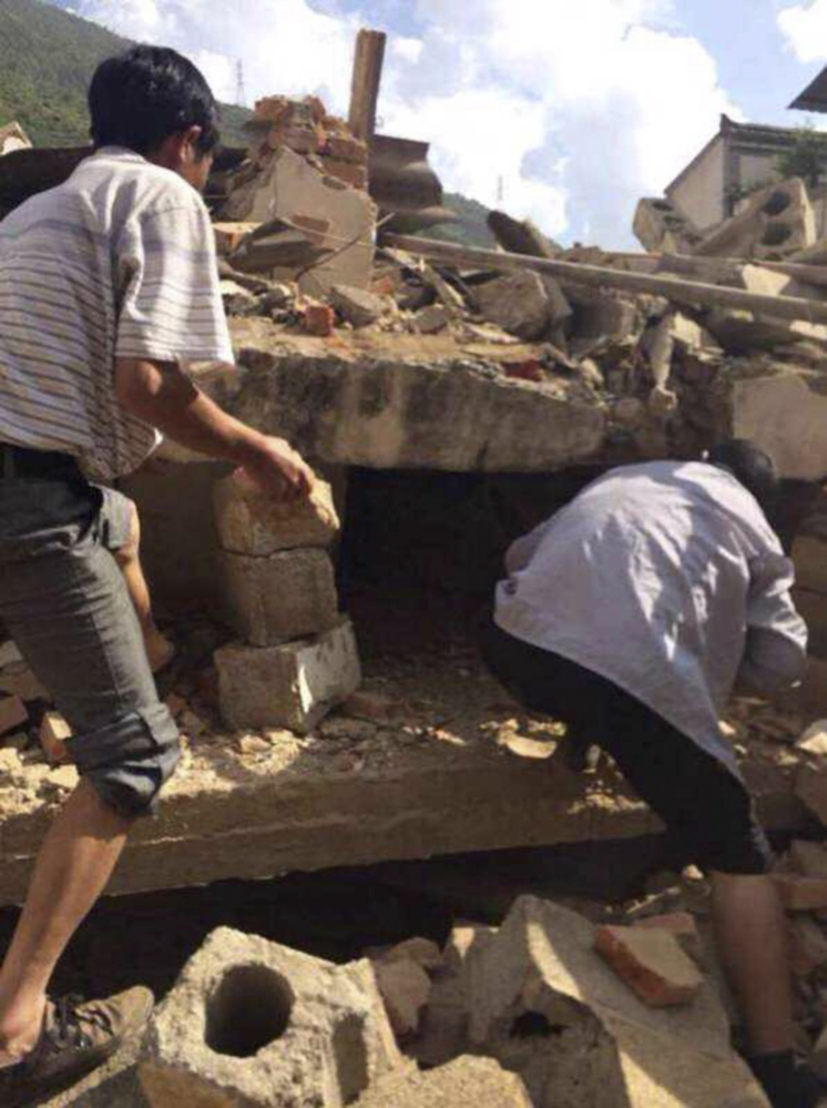 Men search through rubbles of buildings looking for survivors after an earthquake in Ludian County of Zhaotong City in southwest China’s Yunnan Province Sunday.