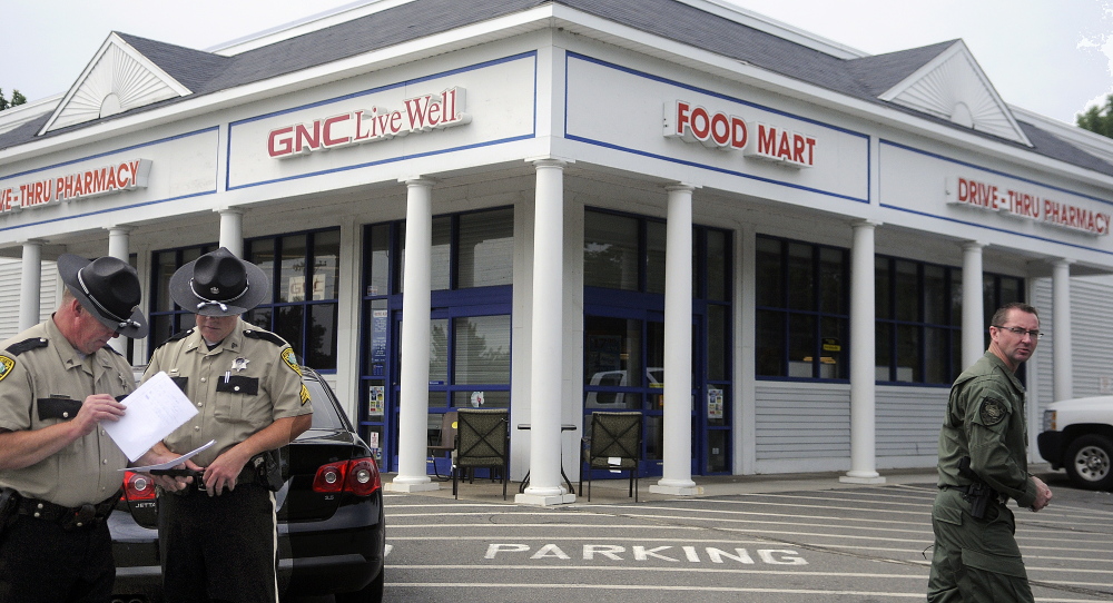 Kennebec County Sheriff’s Deputies review photos of a suspect who allegedly robbed the Rite Aid pharmacy in Manchester on Sunday.