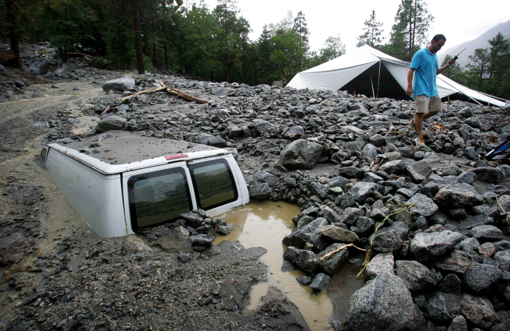 An official of Forest Home Christian Conference Center in Forest Falls, Calif., inspects damage on the property caused by Sunday’s thunderstorms.