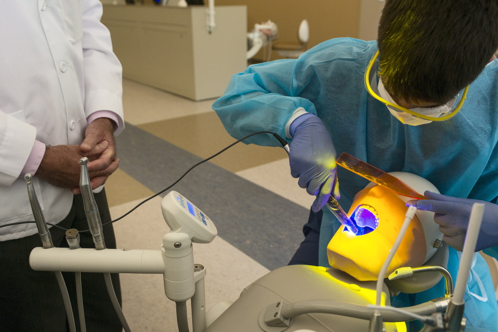 Mounir Majid practices drilling with Dr. Lionel Vachon at University of New England’s dentist camp for high school students on Monday.