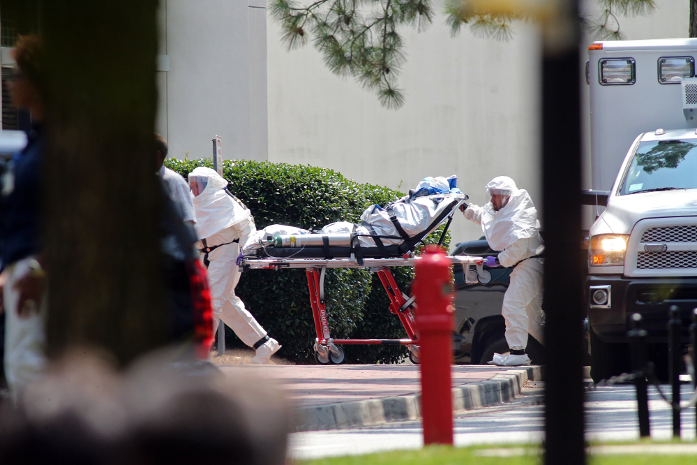 Cloaked in a protective suit, Nancy Writebol, an American aid worker from North Carolina who was infected with the Ebola virus while working in Liberia, arrives at Emory University Hospital in Atlanta on Tuesday.