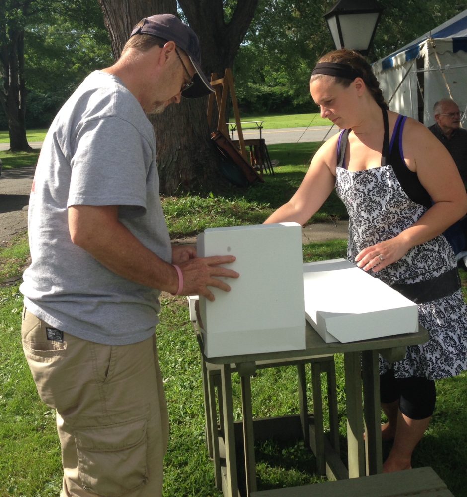 Normal:Jeff Smith, of Winslow, looks through the blueberry pie selection assisted by Amy Fogg at Winslow Congregational Church Friday evening. Smith said he plans on attending Saturday’s Blueberry Festival at the Lithgow Street church.