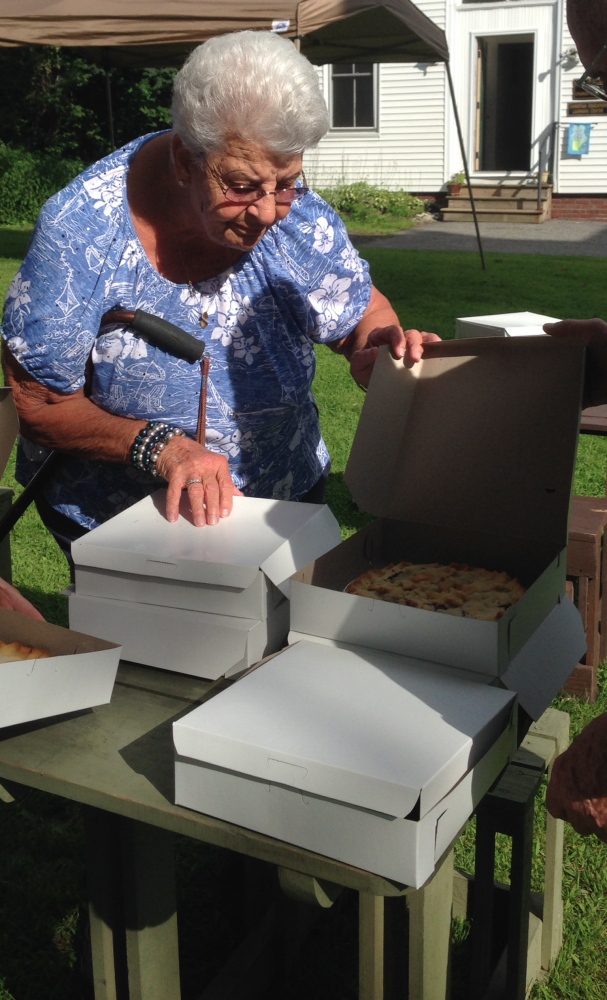 Normal (Web):Pauline Poulin, of Winslow, takes a good look at a blueberry pie before purchasing it Friday night at the Winslow Congregational Church. The church is selling the pies Saturday at its annual Blueberry Festival fundraiser.