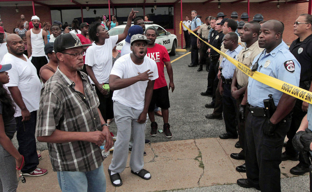 A crowd is stopped by police as they were trying to reach the scene where 18-year-old Michael Brown was fatally shot by police in Ferguson, Mo., near St. Louis on Saturday.