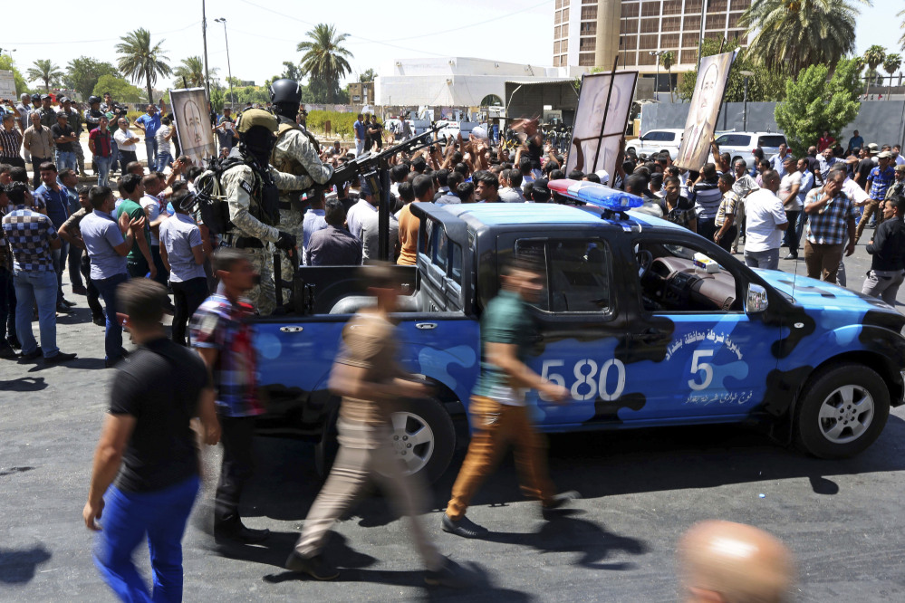Iraqi security forces stand guard amid tight security by Iraqi security forces that sealed off roads around a pro-government demonstration supporting Embattled Prime Minister Nouri al-Maliki,  Iraq, Monday.