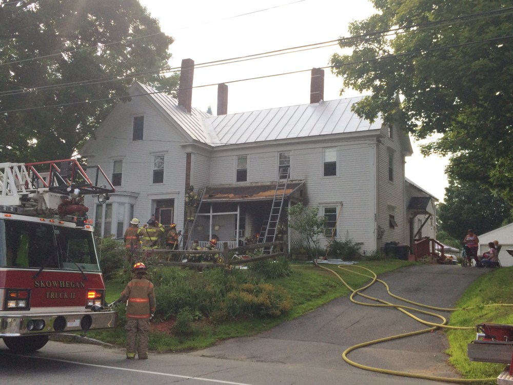 Evelyn McElrath, 89, who uses an oxygen tank, was led from her home on Water Street in Skowhegan by her niece, Sonya Fox, when an improperly disposed cigarette caused a porch fire that damaged the exterior of the house on Monday in Skowhegan.