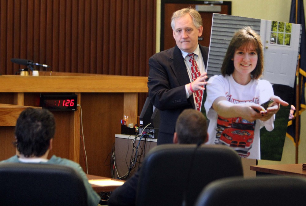 Bob Marriott holds a large photo of his daughter Elizabeth “Lizzy” Marriott as he looks at Seth Mazzaglia, seated left, during a sentencing hearing in Strafford County Superior Court on Thursday in Dover, N.H.