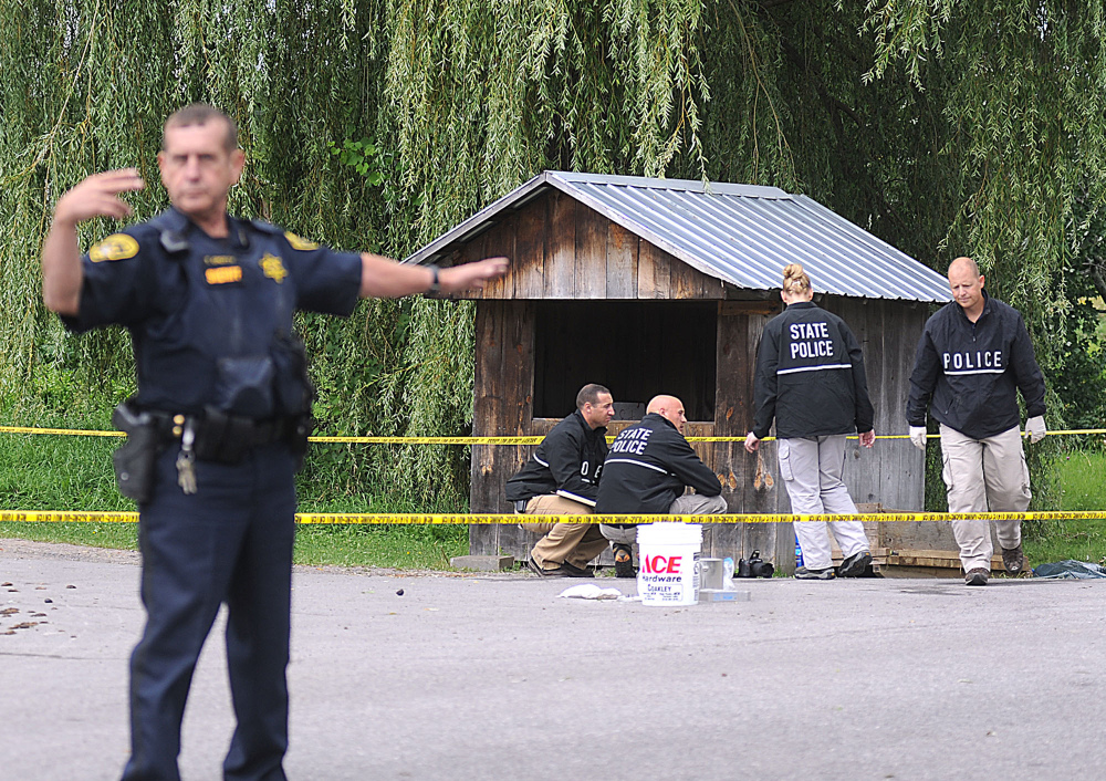 New York State Police crime scene investigators search for clues at a roadside vegetable stand in Oswegatchie, N.Y., on Thursday as they investigate the abduction of two Amish sisters.