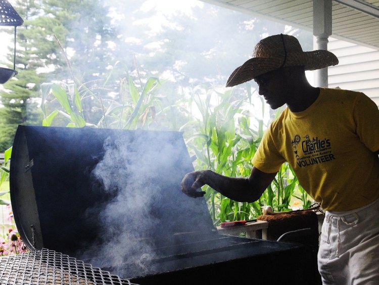 Craig Hickman prepares a smoker on Thursday at his home in Winthrop. He and other volunteers were getting ready for a charity fundraiser that will be held Saturday afternoon on the football field behind the Winthrop Grade School. Hickman, a Democratic state legislator, is a Rotary member who is helping with a fundraiser aimed at eliminating hunger in the Winthrop region.