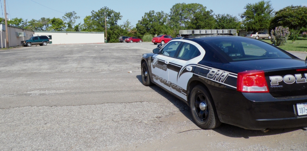 A police vehicle sits outside a North Texas roller skating rink in Grainville, Texas, on Saturday. Two people were stabbed to death and several were wounded in a fight early Saturday.