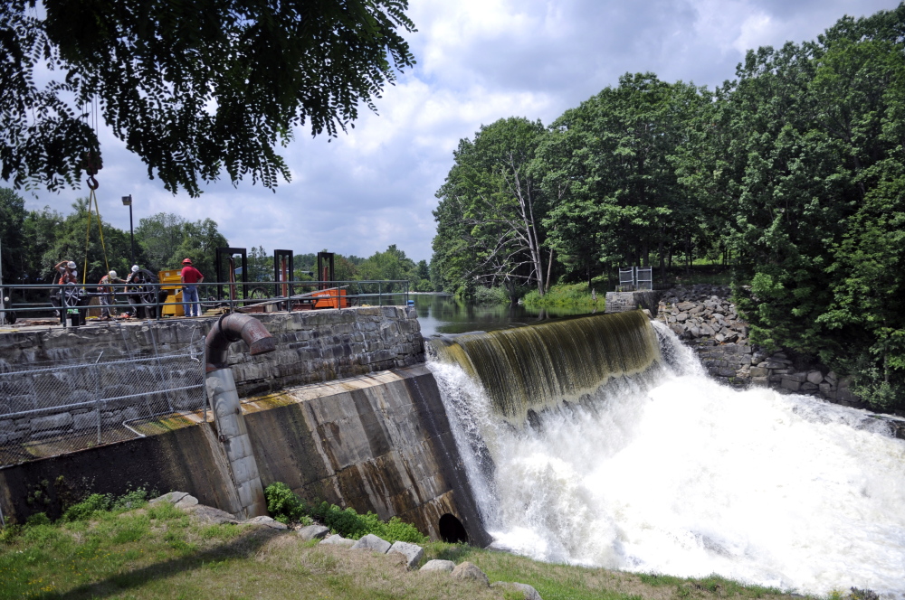 Workers repair a dam in July in Cobbossee Stream in Gardiner where a corridor is proposed through the community.