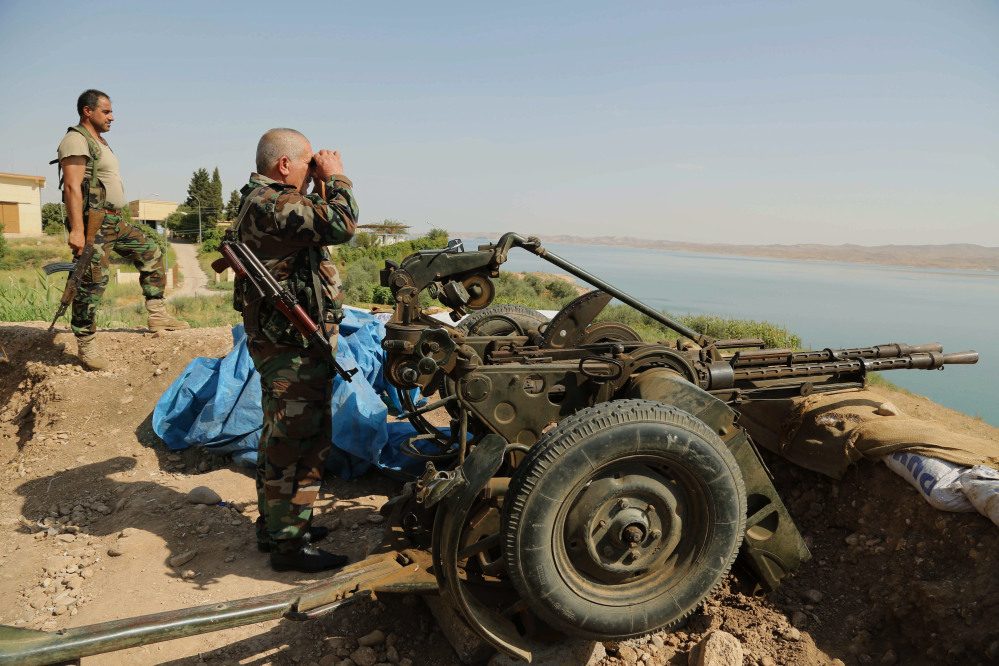 Kurdish forces, known as peshmerga, stand guard near Mosul Dam at the town of Chamibarakat outside Mosul, Iraq, on Sunday. Kurdish forces took over parts of the largest dam in Iraq on Sunday less than two weeks after it was captured by the Islamic State extremist group, Kurdish security officials said.