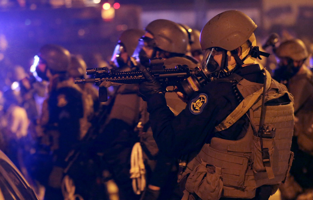 Police advance after tear gas was used to disperse a crowd on Sunday, during a protest for Michael Brown, who was killed by a police officer on Aug. 9 in Ferguson, Mo. As night fell Sunday in Ferguson, another peaceful protest quickly deteriorated after marchers pushed toward one end of a street. Police attempted to push them back by firing tear gas and shouting over a bullhorn that the protest was no longer peaceful.