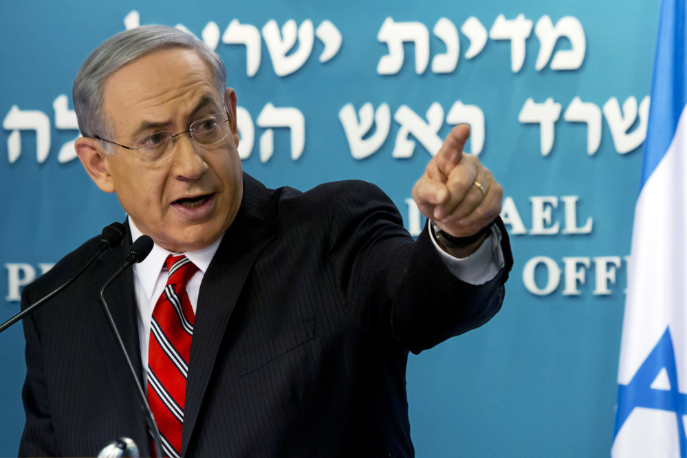 In this Aug. 6, 2014, file photo, Israeli Prime Minister Benjamin Netanyahu points at a video screen showing Hamas militants firing rockets into Israel from areas near schools and Hamas deploying civilians as human shields, as he gives a news conference in Jerusalem.