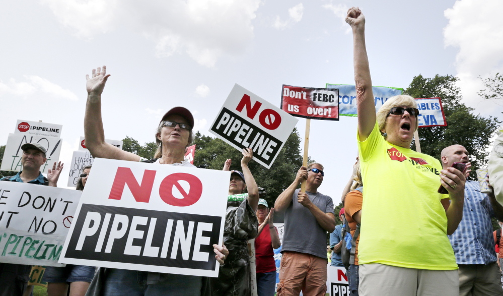 Opponents of a proposed natural gas pipeline protest on Boston Common across from the Statehouse in Boston, Wednesday, July 30, 2014. Energy company Kinder Morgan has proposed the $3.75 billion extension of its northeast pipeline through Massachusetts and says will provide clean-burning natural gas to the northeast. (AP Photo/Charles Krupa)