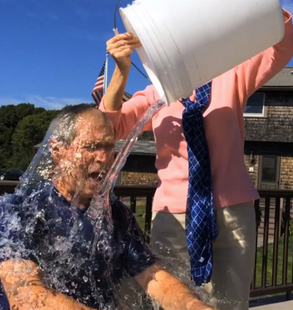 In this image from video posted on Facebook, courtesy of the George W. Bush Presidential Center, former President George W. Bush participates in the ice bucket challenge with the help of his wife, Laura Bush, in Kennebunkport, Maine. The challenge has caught on with notable figures participating in the campaign to raise money for the fight against ALS, or Lou Gehrig's disease. (AP Photo/Courtesy George W. Bush Presidential Center)