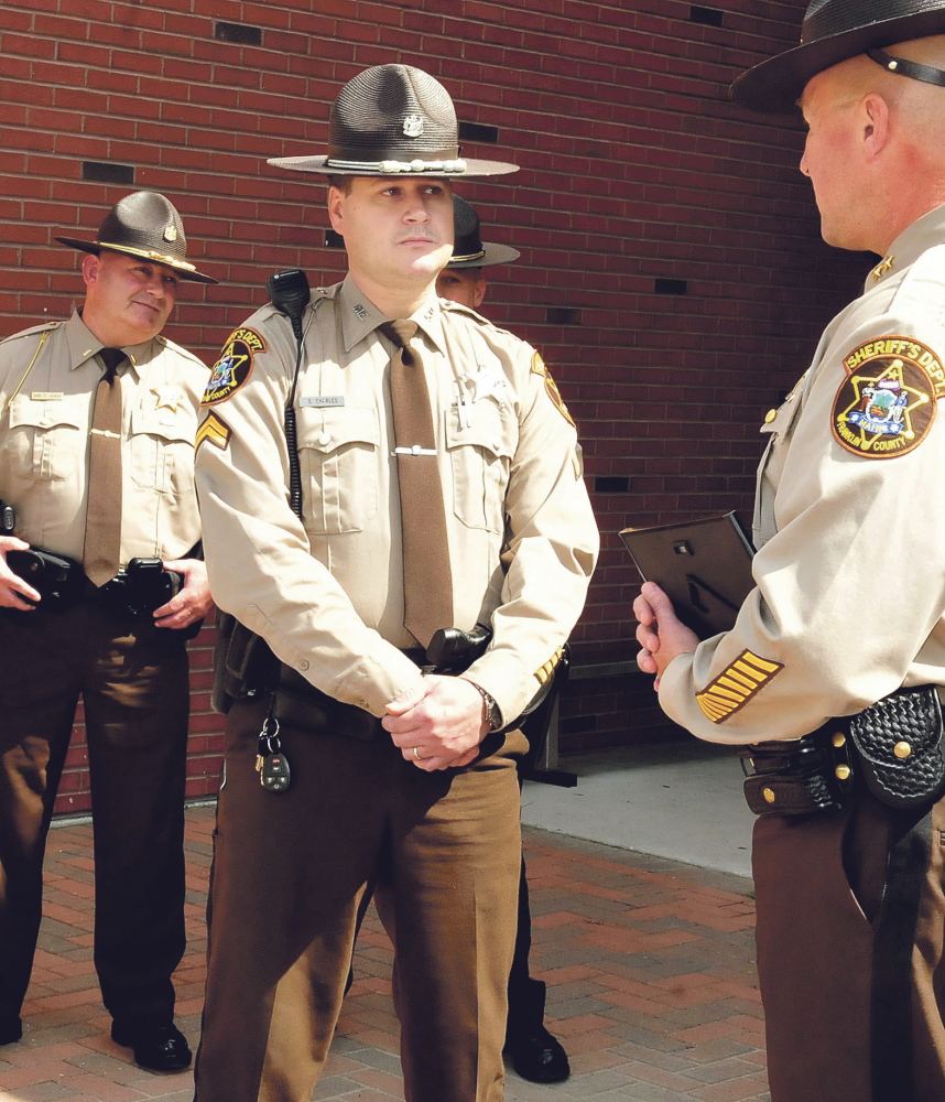Franklin County Sheriff Scott Nichols, right, presents a citation to Detective Steve Charles for his drug investigation work during a swearing-in ceremony at the Somerset County Sheriff’s Office in East Madison on Thursday
