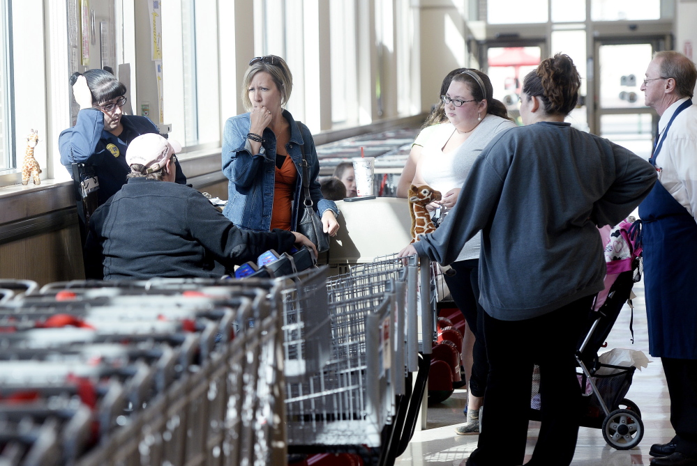 Employees gather at the front of the store at the Market Basket in Biddeford on Friday as they await news on whether their former CEO Arthur T. Demoulas will return to his former job.