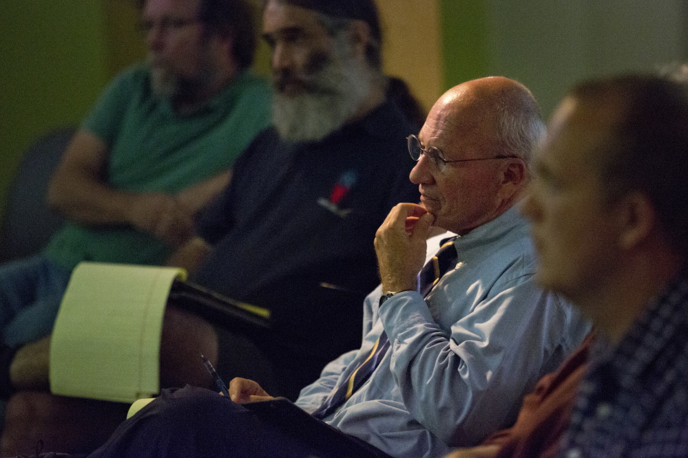 Portland Mayor Michael Brennan listens as restaurant owner David Turin voices his support for an increase in the minimum wage, but not to rescind the current tip credit, at the Portland Public Library on Wednesday.