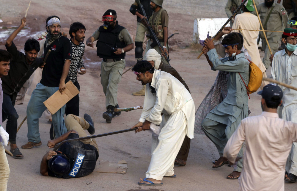 Pakistani protesters beat a police officer in Islamabad. Anti-government protesters stormed Pakistan’s state television building Monday, forcing the channel briefly off the air as they clashed with police and pushed closer to the prime minister’s residence.