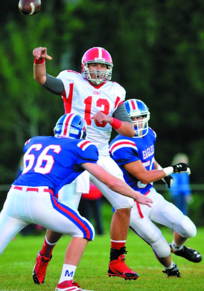 Cony High School quarterback Ben Lucas (13) unloads the ball before getting hit by Messalonskee High School defenders Caleb Bean (66) and Jordan Carson (50) in the first quarter of the season opener at Messalonskee High School last year in Oakland. The Rams and Eagles kick off the season against each other tonight.
