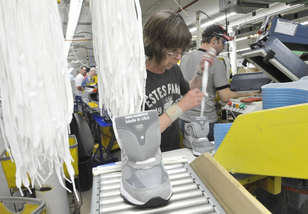 Sharon Estes inserts and laces shoes at New Balance in Norridgewock in this 2011 photo.