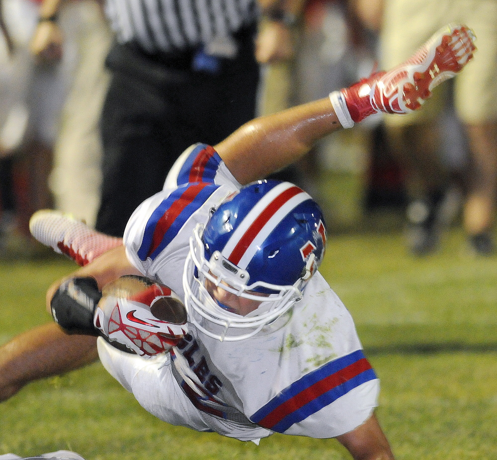 Messalonskee High School’s Jake Bernatchez leaps for a first down during a Pine Tree Conference Class B game Friday night at Alumni Field in Augusta.