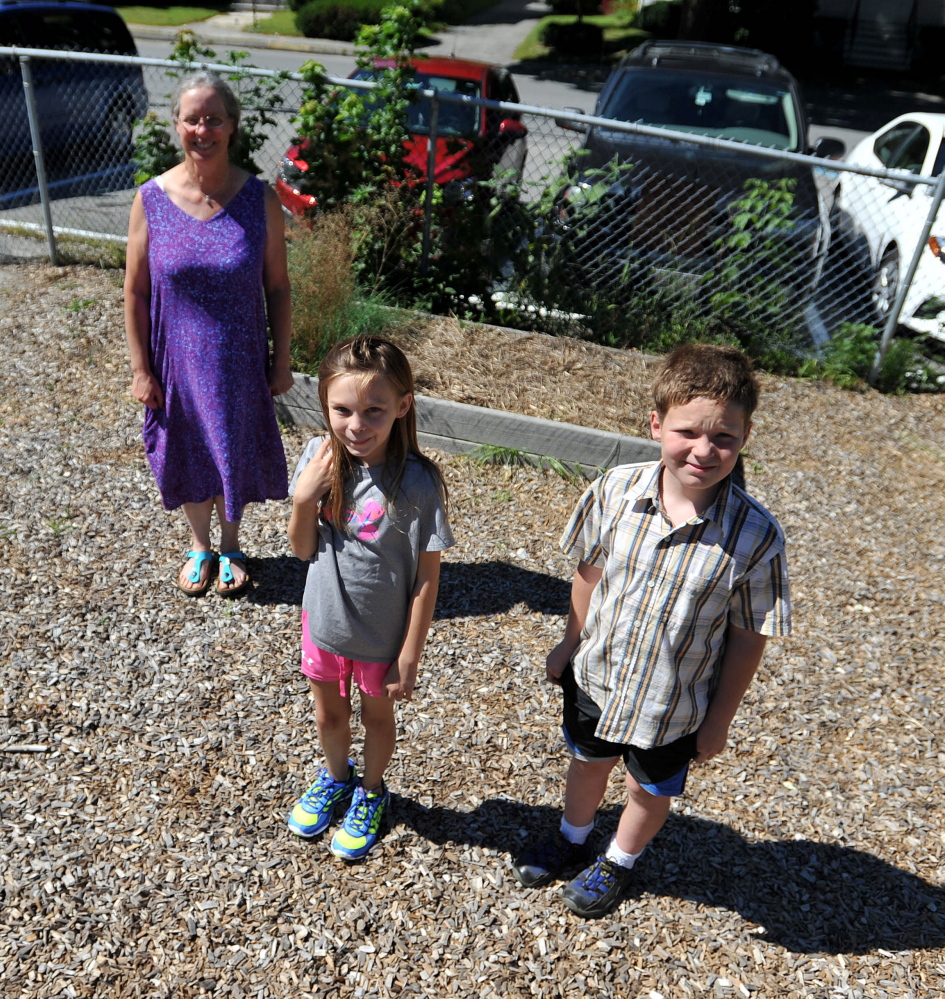 Mary Dunn, a fifth grade teacher at Albert S. Hall School, stands next to the school’s onion patch with students Ashley Harwood, 11, center and Dale Saucier, 10, in Waterville on Thursday. The onions that were grown to be donated to the Mid-Maine Homeless Shelter and used at the school were stolen recently.