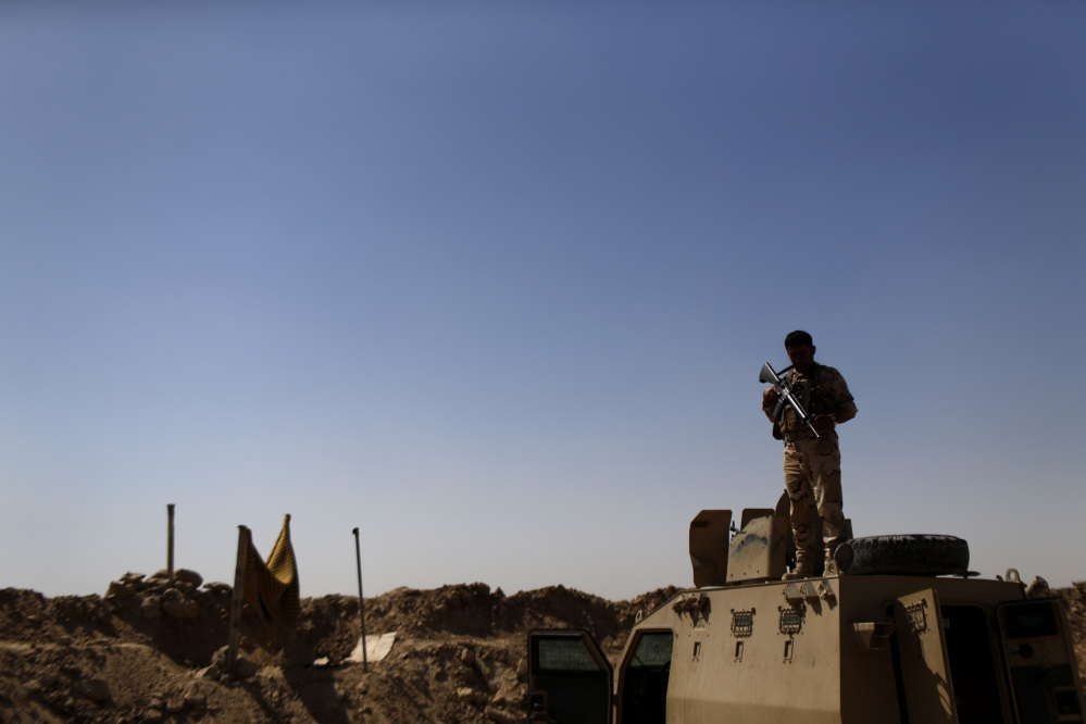 A Kurdish Peshmerga fighter stands guard atop an armored vehicle at a combat outpost on the outskirts of Makhmour, 300 kilometers (186 miles) north of Baghdad, Iraq, Saturday.
