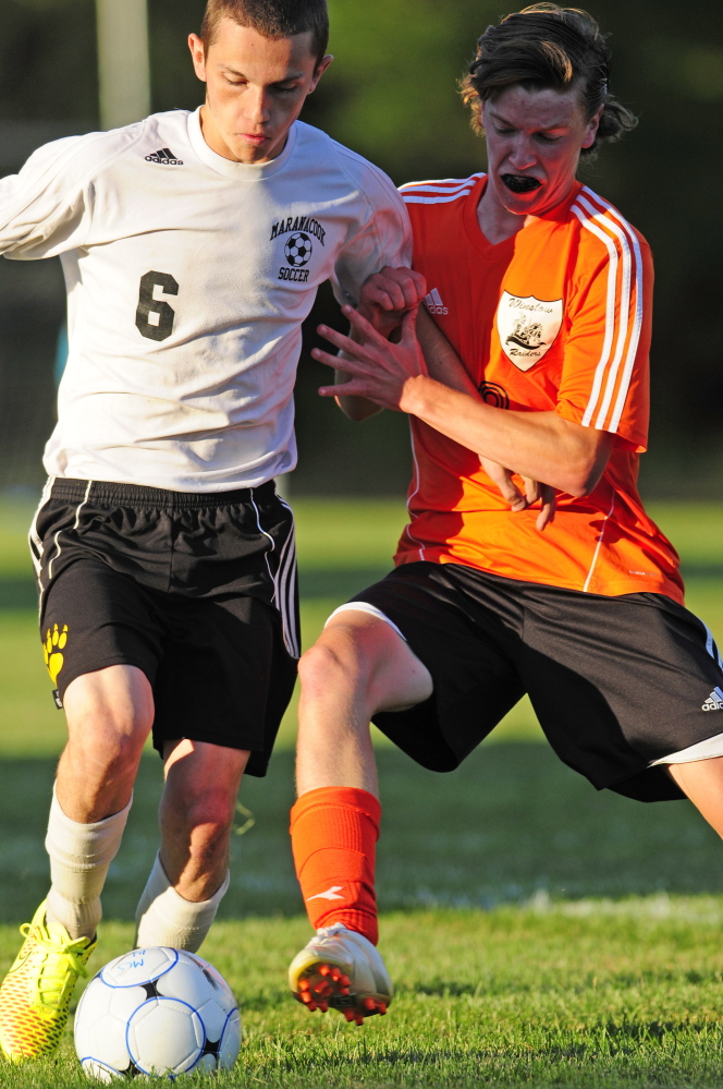Winslow defender Ben Smith, right, kicks the ball away from Maranacook striker Kodey Solmitz Tuesday at the Ricky Gibson Field of Dreams in Readfield.