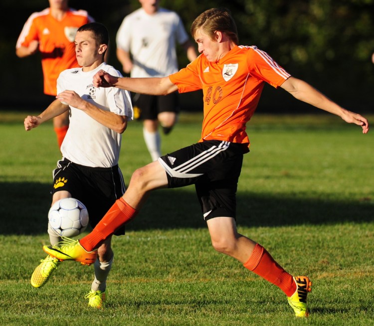 Winslow defender Harrison Clark, right, kicks the ball away from Maranacook striker Kodey Solmitz Tuesday at the Ricky Gibson Field of Dreams in Readfield.