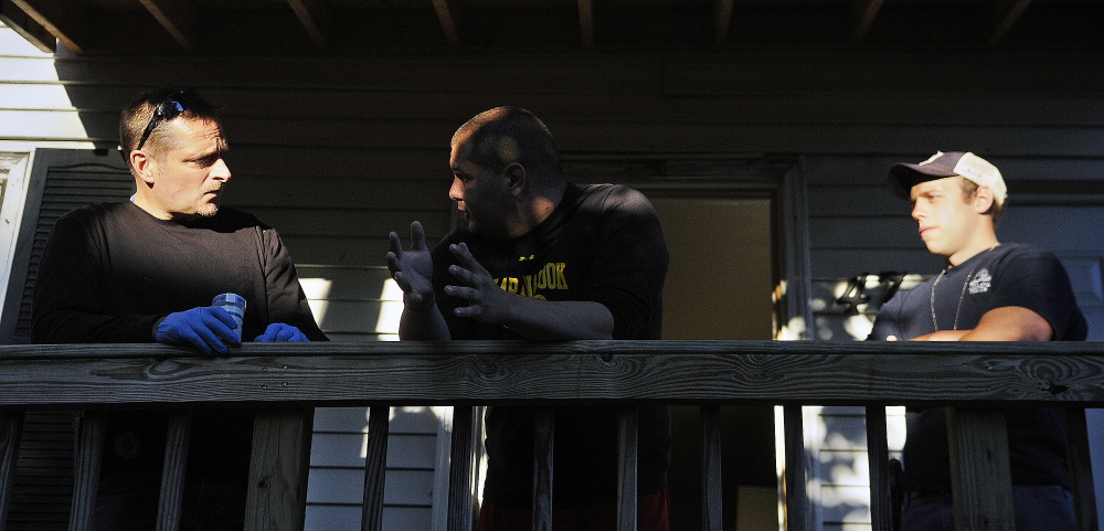 Probation Officer Mark Fortin, left, and Augusta Police Officer Ben Murtiff detain a parolee Thursday after searching his Augusta apartment during a sweep by several law enforcement agencies through the city. Federal, state, county and corrections officers assisted Augusta police in checking multiple individuals on probation in Augusta for violations of their terms of release.
