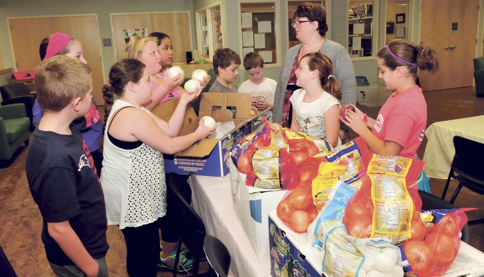 Fifth-grade students from the Albert S. Hall school in Waterville donated hundreds of pounds of onions to the Mid-Maine Homeless Shelter in Waterville on Thursday. The onions the students grew at their school garden this summer were stolen, but people from across the country replaced those donating more than 700 poundsof a variety of onions. Accepting the onions is shelter Executive Assistant Tanya Fossett.