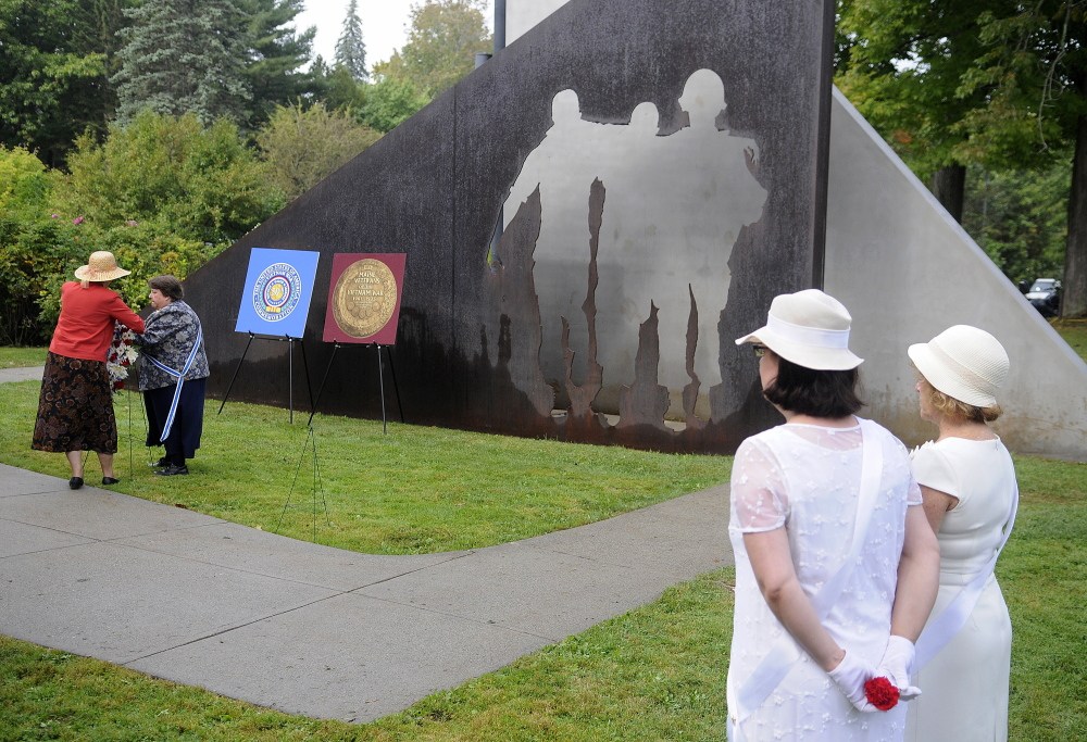 Members of the Daughters of the American Revolution lay a wreath Sunday at the Maine Vietnam Veterans Memorial in Capitol Park during a remembrance for the conflict’s veterans.