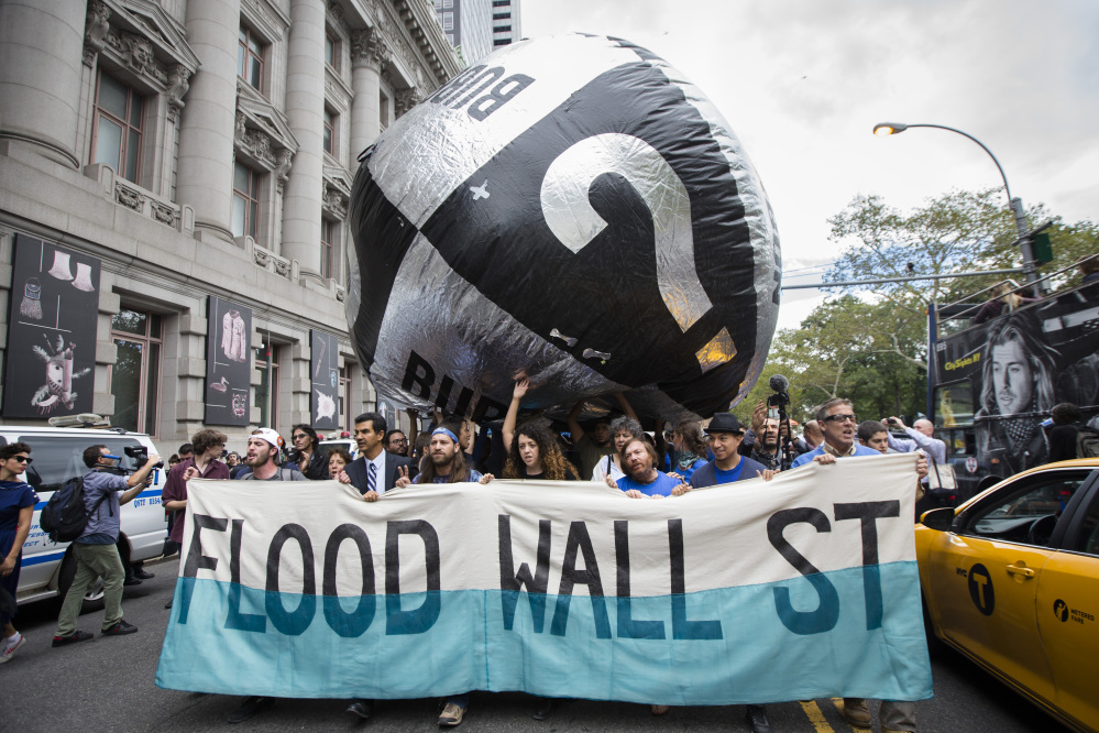 Demonstrators march towards Wall Street from Battery Park to protest for action on climate change and corporate greed Monday, a day after a huge climate march in New York City.