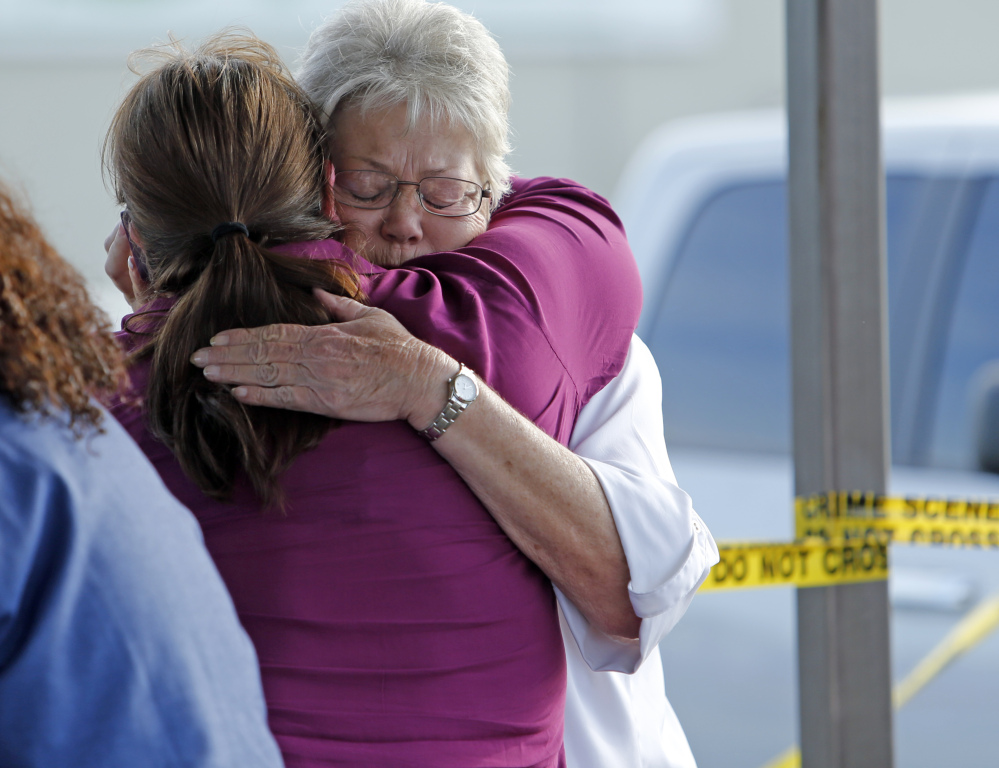 Employees and friends wait behind police tape for word of loved ones as police investigate the beheading of a worker at Vaughn Foods on Thursday in Moore, Okla.