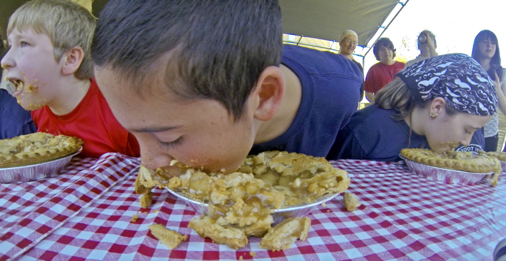 Max Hill, left, Ethan Larabee and Emmaleigh Fish compete in an apple pie eating contest on Saturday during the Monmouth Apple Festival.