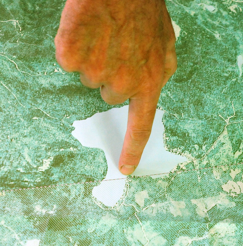 Craig Dickstein, of The Forks, points to his home on a map, which is divided by the town line of Caratunk and The Forks. Dickstein is part of an effort for Pleasant Pond to secede from The Forks and become part of Caratunk.