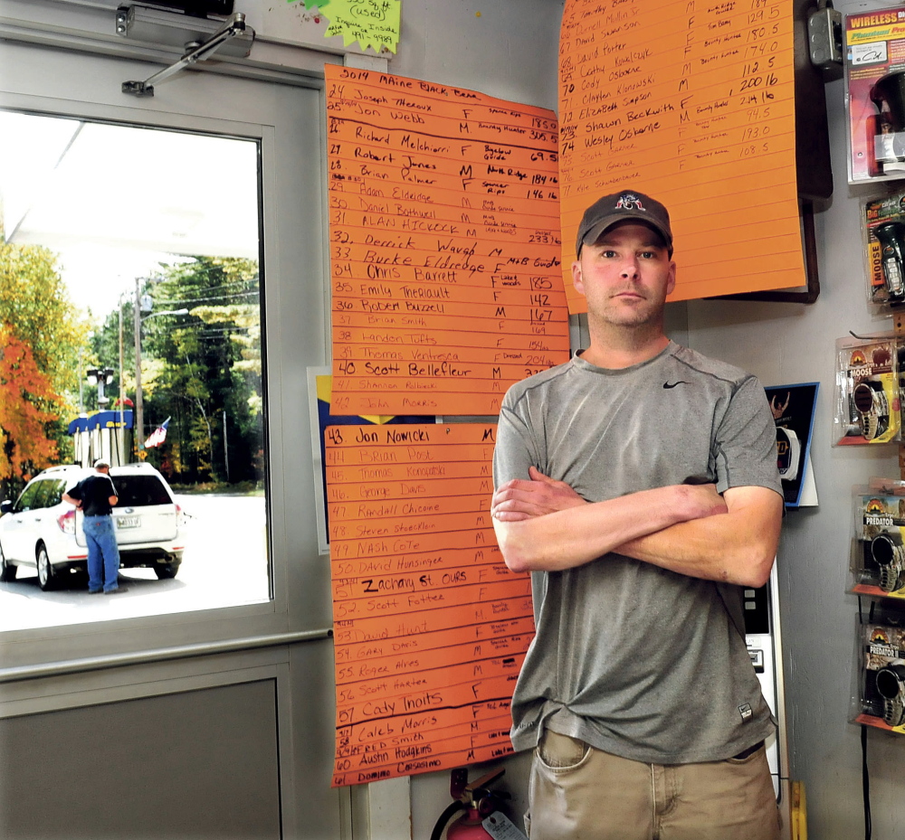 Staff photo by David Leaming
As a customer pumps gasoline outside Pines Market in Eustis, owner John Morris stands beside the tally boards of the 77 bears that have been tagged so far this season. The amount is twice the amount tagged last year. Morris said if the bear referendum passes it would have an adverse impact on his business. “There are plenty of bear around this year,” Morris said.