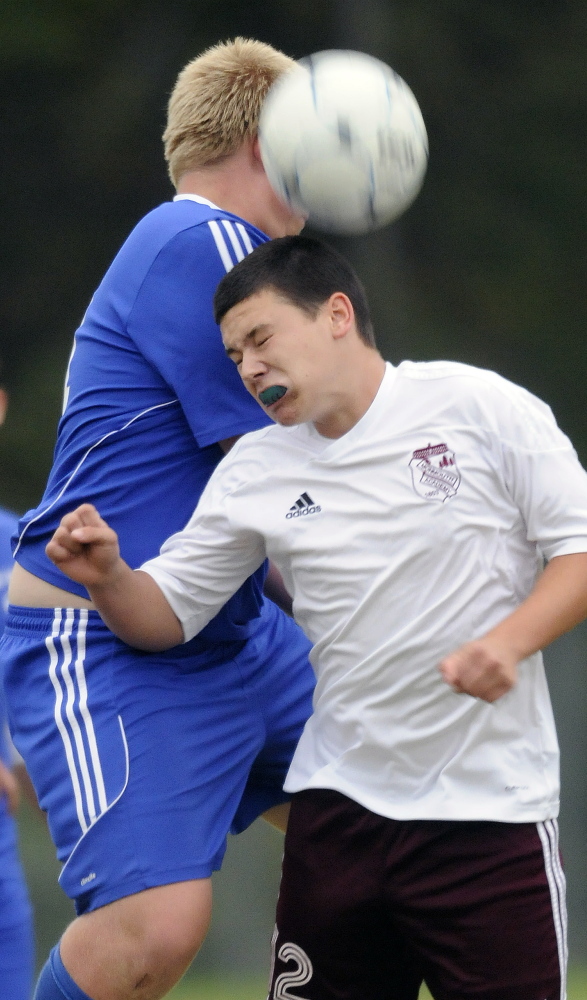 Mt. Abram’s Seamus Allen, left, heads a ball above Monmouth Academy’s Noah Bates during a game Monday in Monmouth.