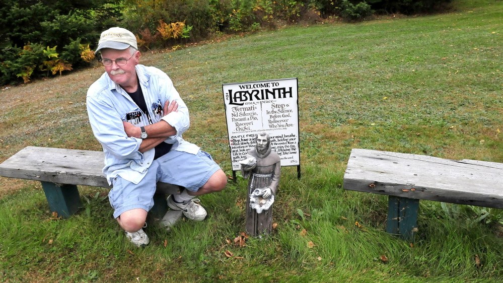 Mike Monahan sits on one of the benches near his Labyrinth walking path at his home in Farmington. People are welcome to walk the paths in solitude and quiet meditation.